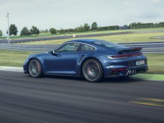 Blauwe Porsche 911 Turbo te hard rijden op een circuit overdag.