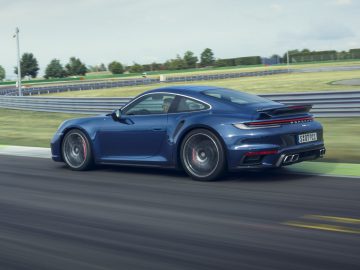 Blauwe Porsche 911 Turbo te hard rijden op een circuit overdag.