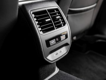 Close-up van het klimaatcontrolepaneel aan de achterkant van een Seat Leon, met verstelbare ventilatieopeningen en temperatuurregelaars.