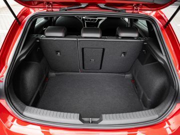 Open kofferbak van een rode Seat Leon met een schone en lege laadruimte met neergeklapte stoelen.