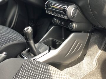 Interieur van een Suzuki Ignis Smart Hybrid met een handgeschakelde versnellingspook, middenconsole en een deel van het dashboard.