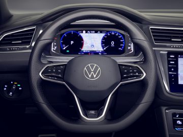 Modern Volkswagen Tiguan-stuur met digitale dashboarddisplays en Volkswagen-logo.