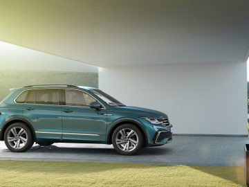 Moderne Volkswagen Tiguan geparkeerd op een minimalistische carport met schilderachtige heuvels op de achtergrond.