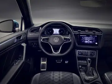Binnenaanzicht van een moderne Volkswagen Tiguan met een digitaal dashboard en touchscreen op de middenconsole.
