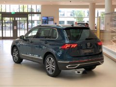 Een Volkswagen Tiguan SUV tentoongesteld in een showroom met grote ramen en heldere binnenverlichting.