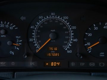 Autodashboard met snelheidsmeter, toerenteller, brandstofmeter en een digitaal display dat de kilometerstand en temperatuur van een Mercedes aangeeft.