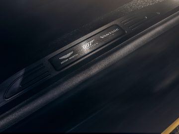 Close-up van een genummerde dorpelplaat van de Aston Martin 007 Edition, die de status van de beperkte editie "007/300" benadrukt.