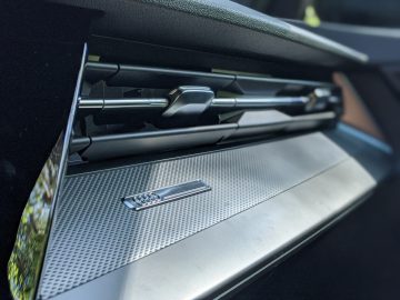 Close-up van een Audi A3-autodashboard met een metallic ontwerp en een zichtbaar merklogo.