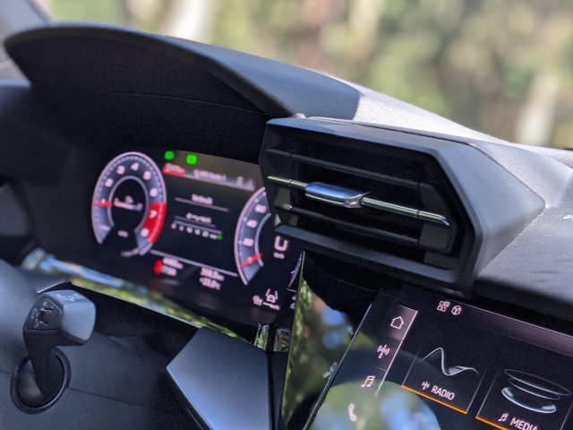 Interieur van een Audi A3 met een digitaal snelheidsmeterdisplay en een multimediabedieningspaneel op het dashboard.