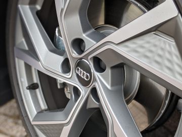 Close-up van een Audi A3-autowiel met ingewikkeld spaakontwerp en zichtbare remschijf.