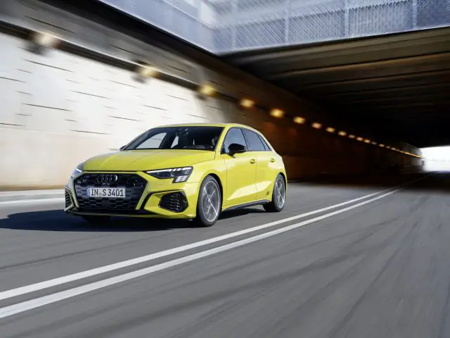 Een gele Audi S3 die door een onderdoorgang rijdt, waardoor bewegingsonscherpte rondom het voertuig zichtbaar is.