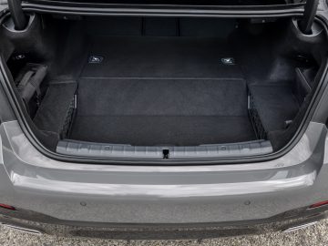 Open kofferbak van een moderne BMW 545e xDrive met een schone en lege laadruimte.
