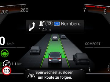 Dashboarddisplay van een BMW 545e xDrive met snelheidsmeter, navigatie naar Nürnberg, adaptieve cruisecontrol en diverse indicatoren.