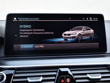 Het infotainmentsysteemscherm van de BMW 545e xDrive met opties voor hybride rijmodi met een afbeelding van een hybride auto.