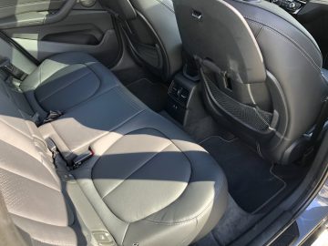 Binnenaanzicht van een BMW X1 xDrive25i met twee voorstoelen, middenconsole en dashboard bij daglicht.