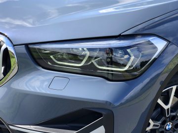 Close-up van een BMW X1 xDrive25i-autokoplamp met opvallend LED-lichtontwerp.