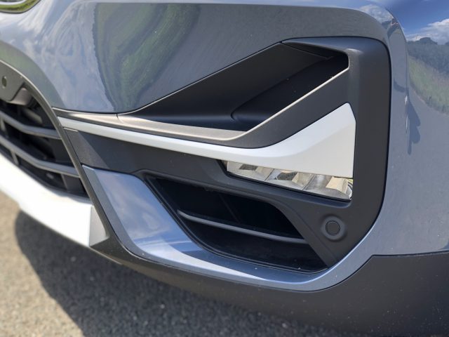 Close-up van de grille en koplamp van een moderne BMW X1 xDrive25i, waarbij het strakke ontwerp en de chromen accenten worden benadrukt.