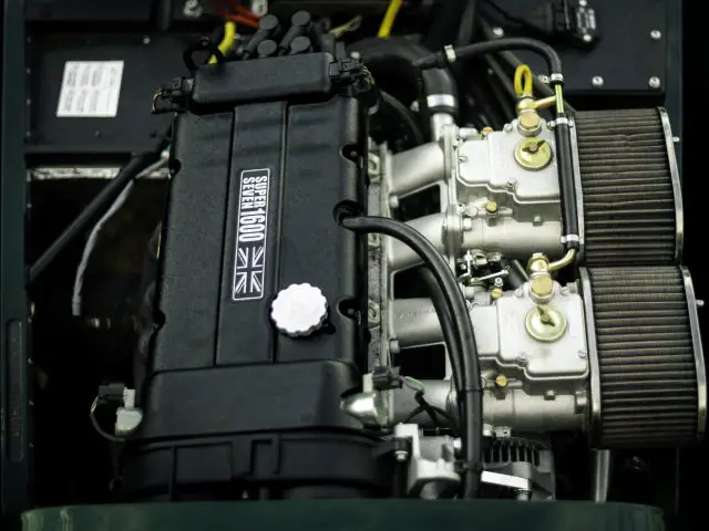 Een close-up van een moderne automotor met een prominent label "Caterham Super Seven 1600" op de omslag.