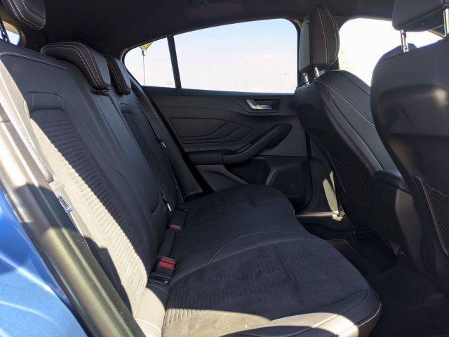 Binnenaanzicht van een Ford Focus ST met de achterstoelen, deurpanelen en ramen, met de nadruk op de strakke zwarte bekleding.