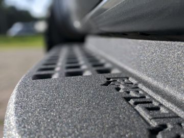 Close-up van een gestructureerd metalen oppervlak met het woord "Ranger" in reliëf, waarbij de nadruk ligt op de textuur met een onscherpe achtergrond.