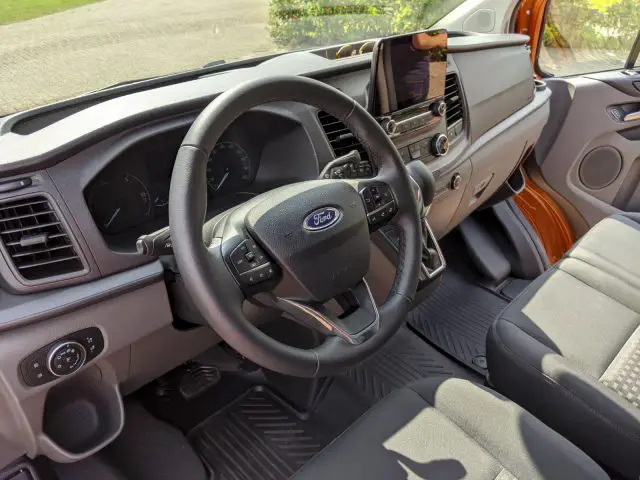Binnenaanzicht van een Ford Transit Custom met het stuur, het dashboard en de voorstoelen.