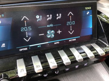 De klimaatbeheersingsinterface van de Peugeot 508 HYbrid die temperatuurinstellingen en AC-bedieningselementen weergeeft, met fysieke knoppen onder het scherm.