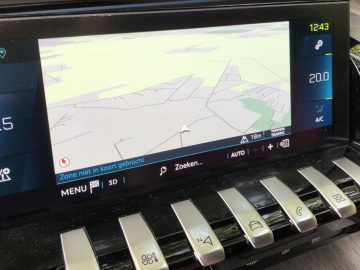 Autodashboard in de Peugeot 508 HYbrid met een navigatiekaart op het scherm en klimaatregelingsinstellingen.