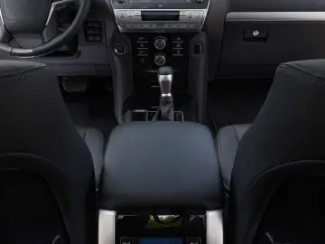 Binnenaanzicht van een Toyota Land Cruiser met het dashboard, het stuur en de middenconsole met handgeschakelde versnellingsbak.