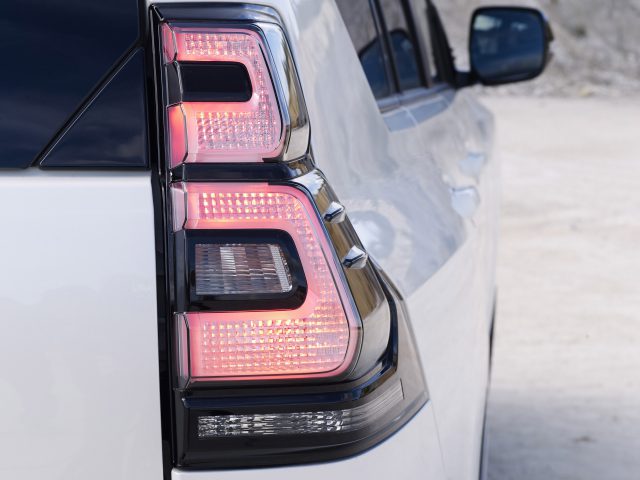 Close-up van het verlichte led-achterlicht aan de achterkant van een Toyota Land Cruiser, met de nadruk op het ingewikkelde ontwerp, buiten geparkeerd.