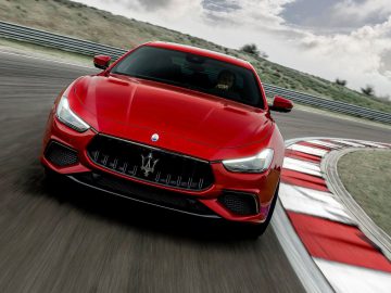 Maserati Ghibli-sportwagen die op een racecircuit rijdt en snelheid en behendigheid tentoonspreidt.