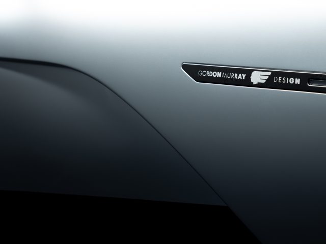 Close-up van het zijpaneel van een auto met het embleem "Gordon Murray Automotive T.50".