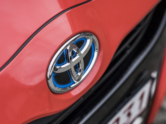Close-up van een rode Toyota Yaris met het logo op de grille.