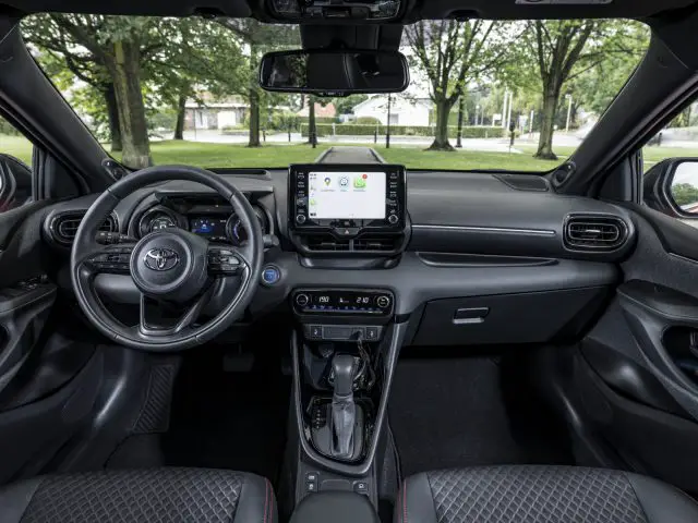 Binnenaanzicht van een Toyota Yaris met het stuur, het dashboard en de middenconsole met touchscreen.