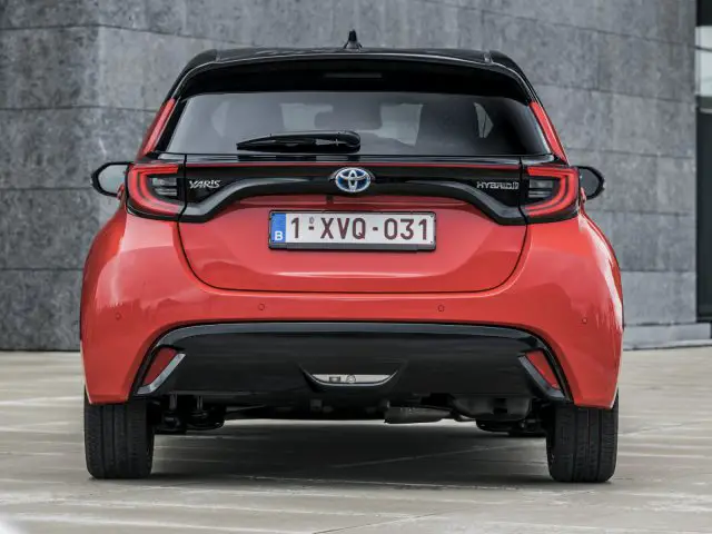 Achteraanzicht van een Toyota Yaris geparkeerd op een stenen stoep met een kentekenplaat met de tekst "1-xvq-031".