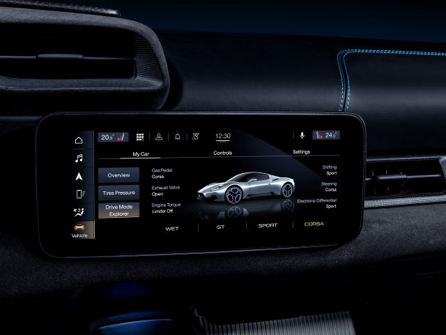 Het infotainmentscherm van de auto met verschillende voertuiginstellingen en een afbeelding van een Maserati MC20-sportwagen.