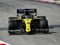 Een Renault Formule 1-raceauto snelt over een circuit, met prominent de sponsorlogo's en een nummer 3 op de voorkant.