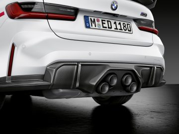 Achteraanzicht van een witte BMW M3 Sedan met quad-uitlaten en een sportieve diffuser, met een Europees kenteken met de tekst "ED 1180".