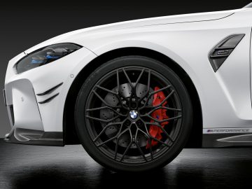 Witte BMW M3 Sedan met de nadruk op het voorwiel en het spatbord, wat het strakke design en de rode remklauwen benadrukt.