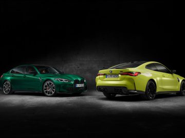 Twee BMW M3 Sedan-auto's, een groene en een gele, geparkeerd in een slecht verlichte kamer, in tegengestelde richting gericht.