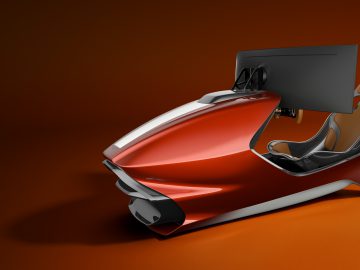 Een futuristische rode Aston Martin racesimulator met ingebouwde stoel en grote monitor, op een oranje achtergrond.