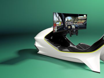 Futuristische Aston Martin-racesimulatoropstelling met een gebogen scherm, stuurwiel en moderne witte cockpitstoel op een groene achtergrond.