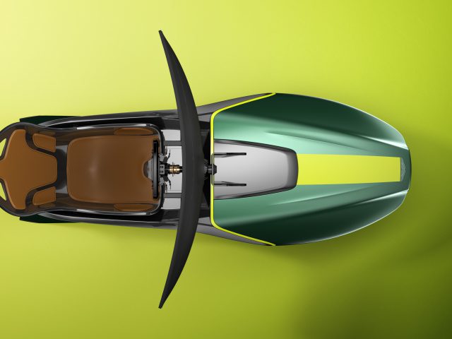Top-down mening van een groene en zwarte Aston Martin-sportmotorfiets op een gele achtergrond.