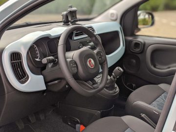 Binnenaanzicht van een Fiat Panda met het stuur, het dashboard en de bestuurdersstoel.