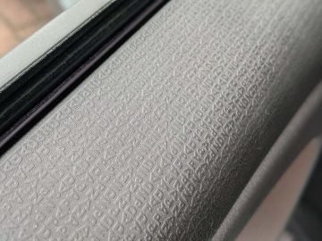 Close-up van getextureerde rubberen raamafdichting in een Fiat Panda, met een gedetailleerd korrelig patroon.