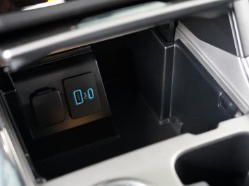 Binnenaanzicht van het opbergvak van een Ford Explorer PHEV met een USB-poort en een elektronisch display met een slotpictogram.