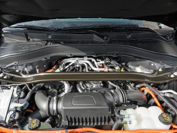 Gedetailleerd overzicht van een open Ford Explorer PHEV-motorkap met een hybride motor met zichtbare componenten, waaronder kabels en batterijen.