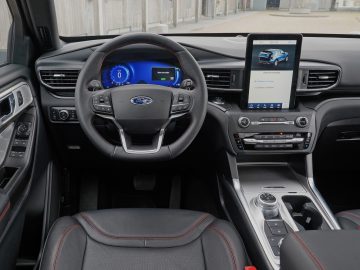 Binnenaanzicht van een moderne Ford Explorer PHEV met het stuur, het digitale dashboard en een middenconsole met touchscreen.