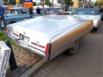 Een vintage Cadillac Eldorado cabriolet geparkeerd op straat tijdens de Saturday Night Cruise 2020, met zijn klassieke ontwerp met opvallende achtervinnen en een wit en goud kleurenschema.