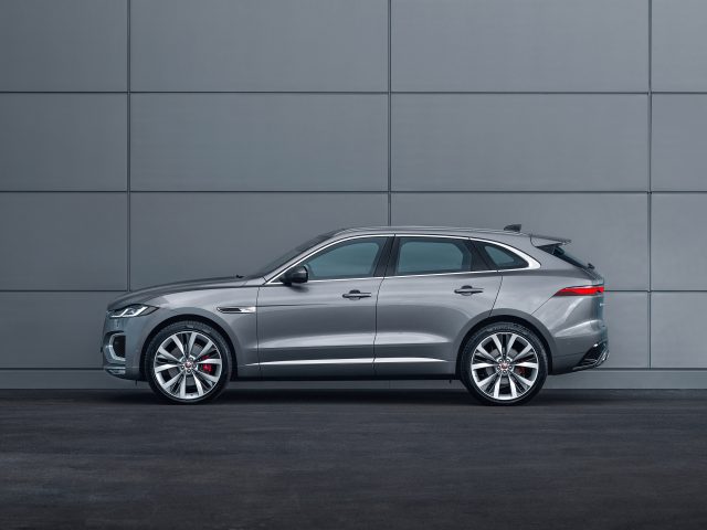 Een zilveren Jaguar F-Pace luxe SUV geparkeerd naast een grijze betonnen muur, met een modern en strak ontwerp met glanzende lichtmetalen velgen.