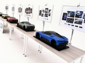 Maserati Grecale-modellen tentoongesteld op tafels naast ontwerpschetsen en moodboards in een lichte studioomgeving.